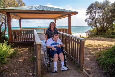 Man in a wheelchair with his carer 