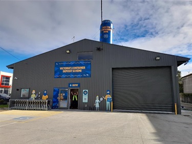 Image of grey warehouse with signage text 'Victoria's Container Deposit Scheme'