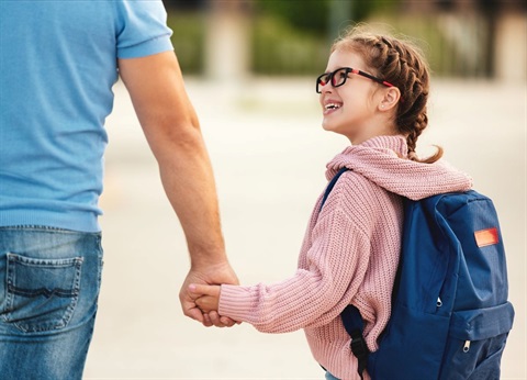 Young girl walking to school holding her dad's hand.jpg